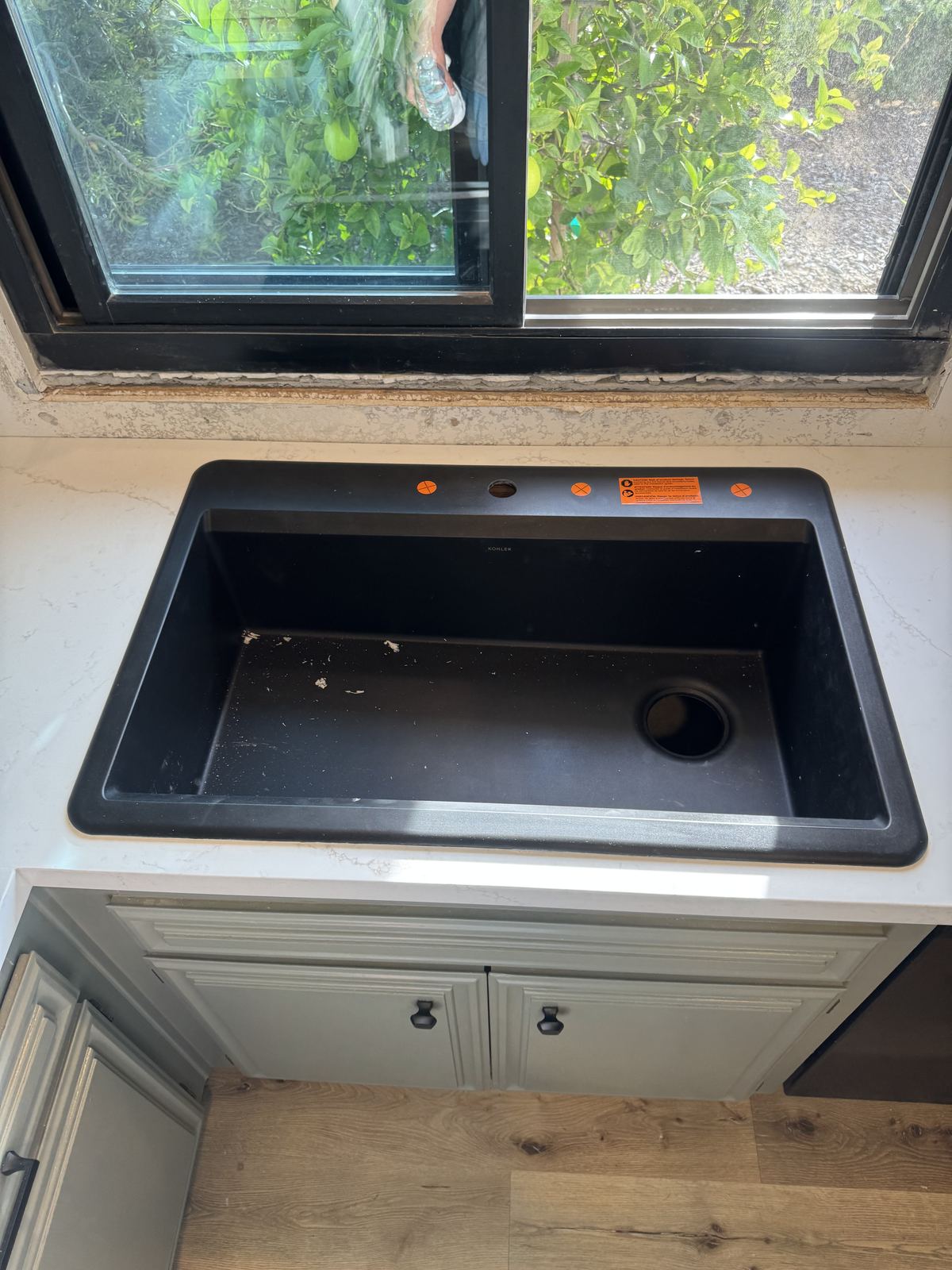 Black Kohler sink set beneath the window — kitchen countertop installation