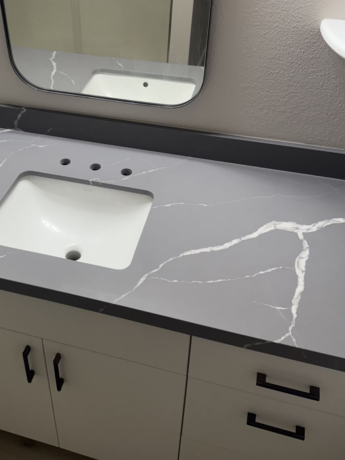 Gray quartz vanity with matching backsplash — bathroom vanity countertop